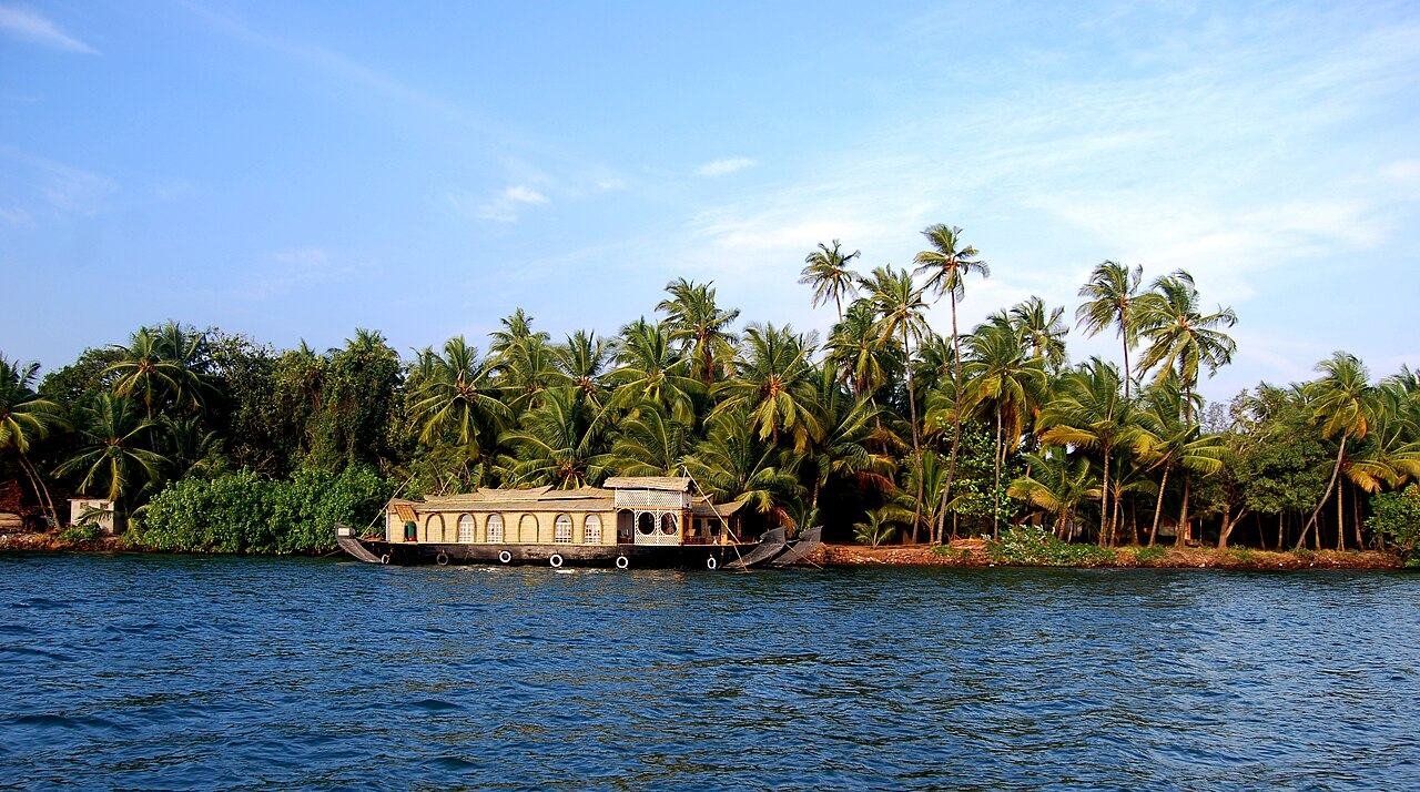 Houseboat on the Karli river lined with coconut palms