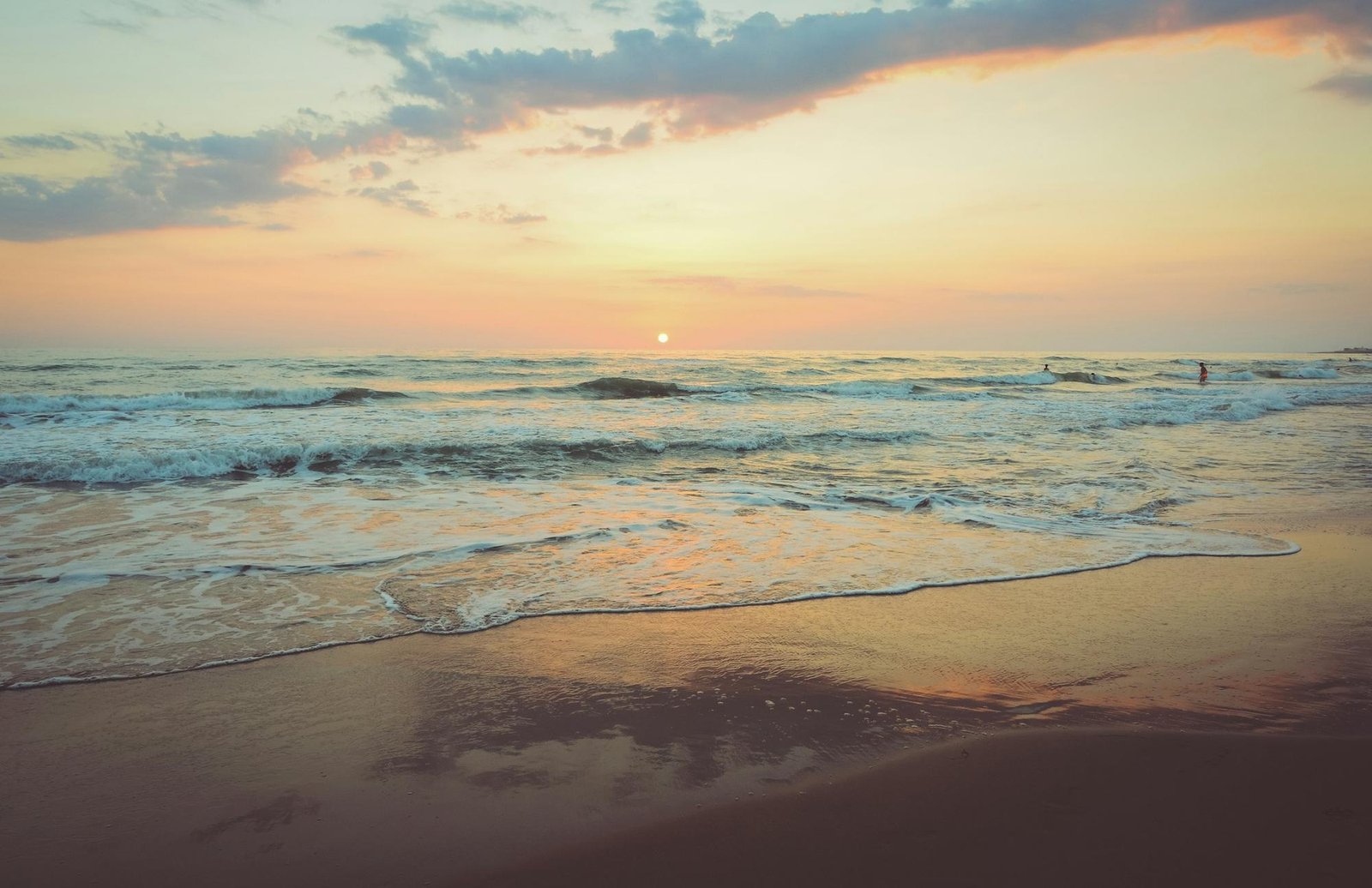Waves rolling onto the sand at sunset